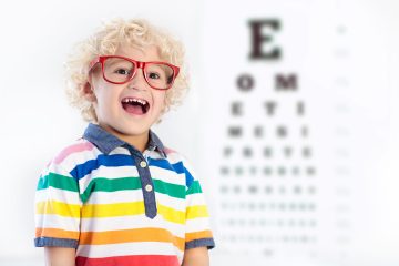 Child at eye sight test. Little kid selecting glasses at optician store. Eyesight measurement for school kids. Eye wear for children. Doctor performing eye check. Boy with spectacles at letter chart.